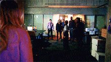 a group of people are standing in a room with boxes on the floor