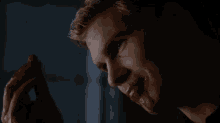 a man with blood on his face is holding a piece of meat in his hand