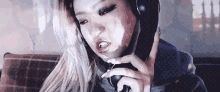 a woman is wearing headphones and talking on a phone .