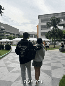 a man and a woman are walking down a sidewalk with the words love you below them
