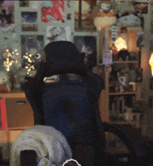 a blurry picture of a room with a chair in the foreground and a shelf in the background