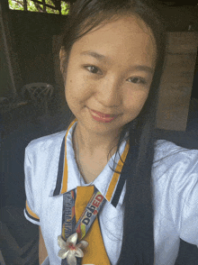 a girl taking a selfie with a lanyard that says dgled
