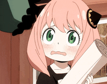 a little girl with pink hair and green eyes is holding a piece of paper