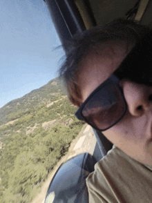 a man wearing sunglasses is looking out of a window