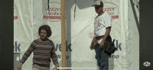 two men are standing in front of a lezze lumber sign