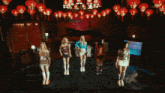 a woman sits at a table in a dark room with red lanterns