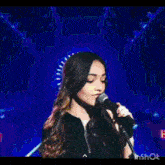 a woman singing into a microphone with the words star maker in the background