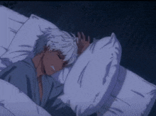 a man is sleeping in a bed with a pillow and a blanket .