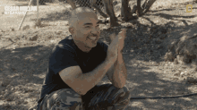a man kneeling down with a national geographic logo in the corner