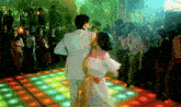 a man and woman are dancing on a dance floor in front of a crowd of people .