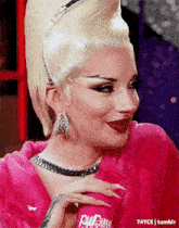 a woman is holding a pink can that says rupaul