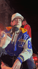 a man wearing a varsity jacket with the letter v on it