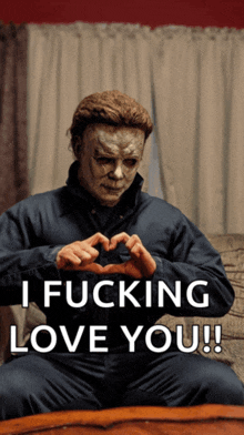 a man in a mask is making a heart shape with his hands with the words i fucking love you below him