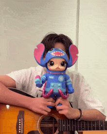 a man is holding a toy that has a space suit on