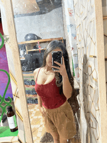 a woman taking a picture of herself in a mirror with her phone