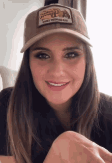 a woman wearing a hat that says shots with guns