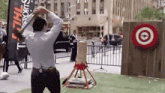 a man throws a axe at a target with a sign that says stihl sports