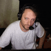 a man wearing headphones and a microphone is looking at a monitor