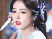 a close up of a woman applying makeup to her face .