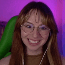 a close up of a woman wearing glasses and smiling