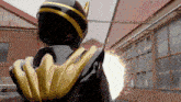 a person in a black and gold costume is standing in front of a brick building