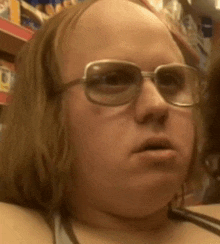 a close up of a person wearing glasses and a bald head .