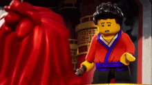 a lego character is holding a sword in front of a red cape