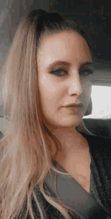a close up of a woman 's face in a car with a ponytail .
