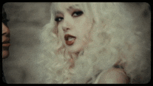 a close up of a woman 's face with blonde hair and red lips
