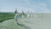 a group of girls are standing in a grassy field with their arms in the air and one has the number 5 on her shirt