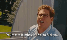a man with glasses is screaming that his taste in music is shit so fuck you