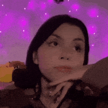 a close up of a woman 's face with a purple background .