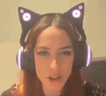 a woman wearing headphones with cat ears on her head is talking .
