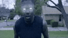 a blurry picture of a man with glowing eyes standing in front of a tree .
