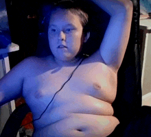 a shirtless man is sitting in a chair with headphones on his head .