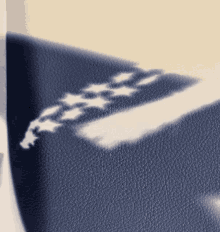 a shadow of a flag is cast on a blue leather surface
