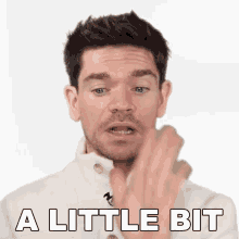 a man in a white jacket says a little bit with his finger