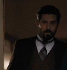 a man with a beard wearing a suit and vest