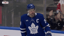 a hockey player for the toronto maple leafs stands on the ice