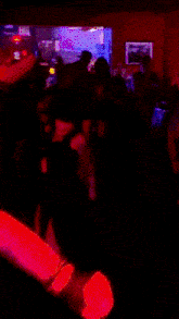 a blurry photo of people dancing in a dark room with purple lights