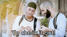 two men looking at something with the words yo check it out