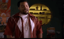 ice cube is wearing a red shirt and a white shirt with a cross necklace