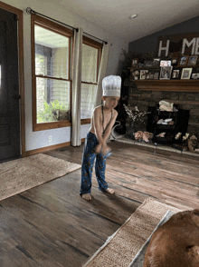 a little boy in a chef 's hat is playing with a toy in a living room