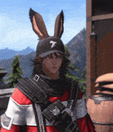 a man wearing bunny ears and a black hat with a white bird on it