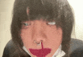 a close up of a person 's face with a nose ring and red lipstick .