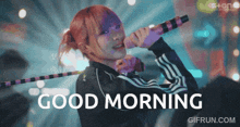 a girl singing into a microphone with the words " good morning " below her