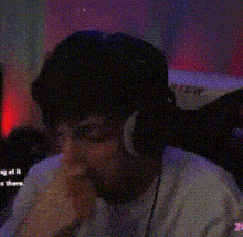 a man wearing headphones looks at the camera with a dollar sign behind him