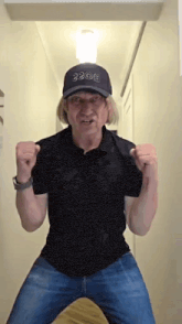 a man wearing a black shirt and a hat with the number 2306 on it