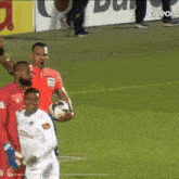 a referee holds a soccer ball in front of a sign that says deport