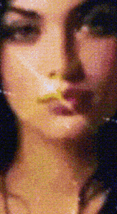 a close up of a woman 's face with a yellow star on her nose